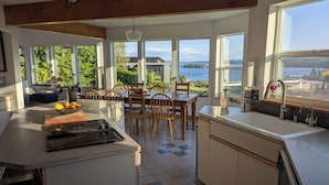 Una cocina moderna con una isla central, ventanas amplias y vistas al agua.