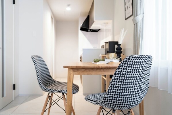 Un espace repas moderne avec une table en bois et deux chaises à motifs.
