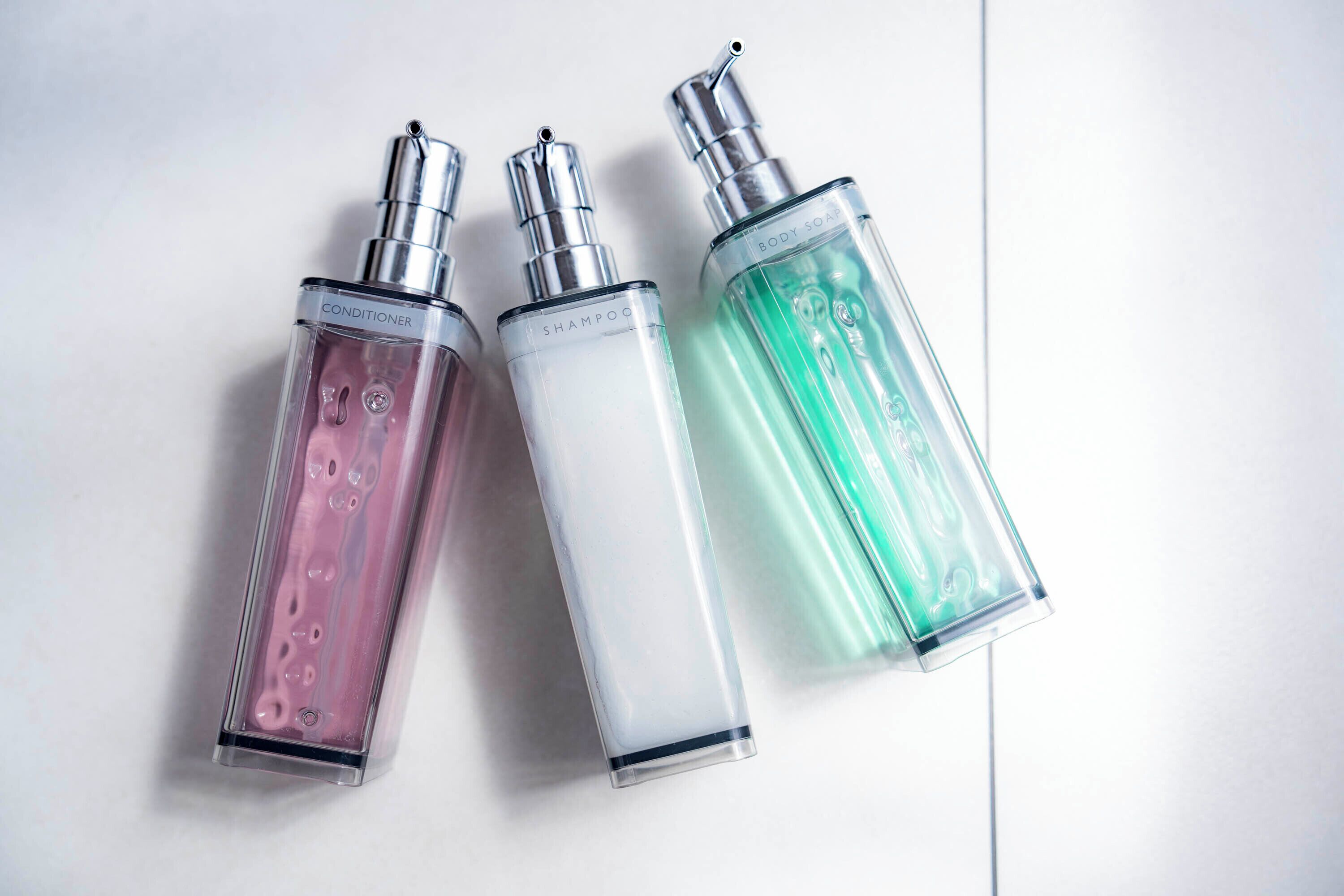 Three bottles of body soap on a white surface.