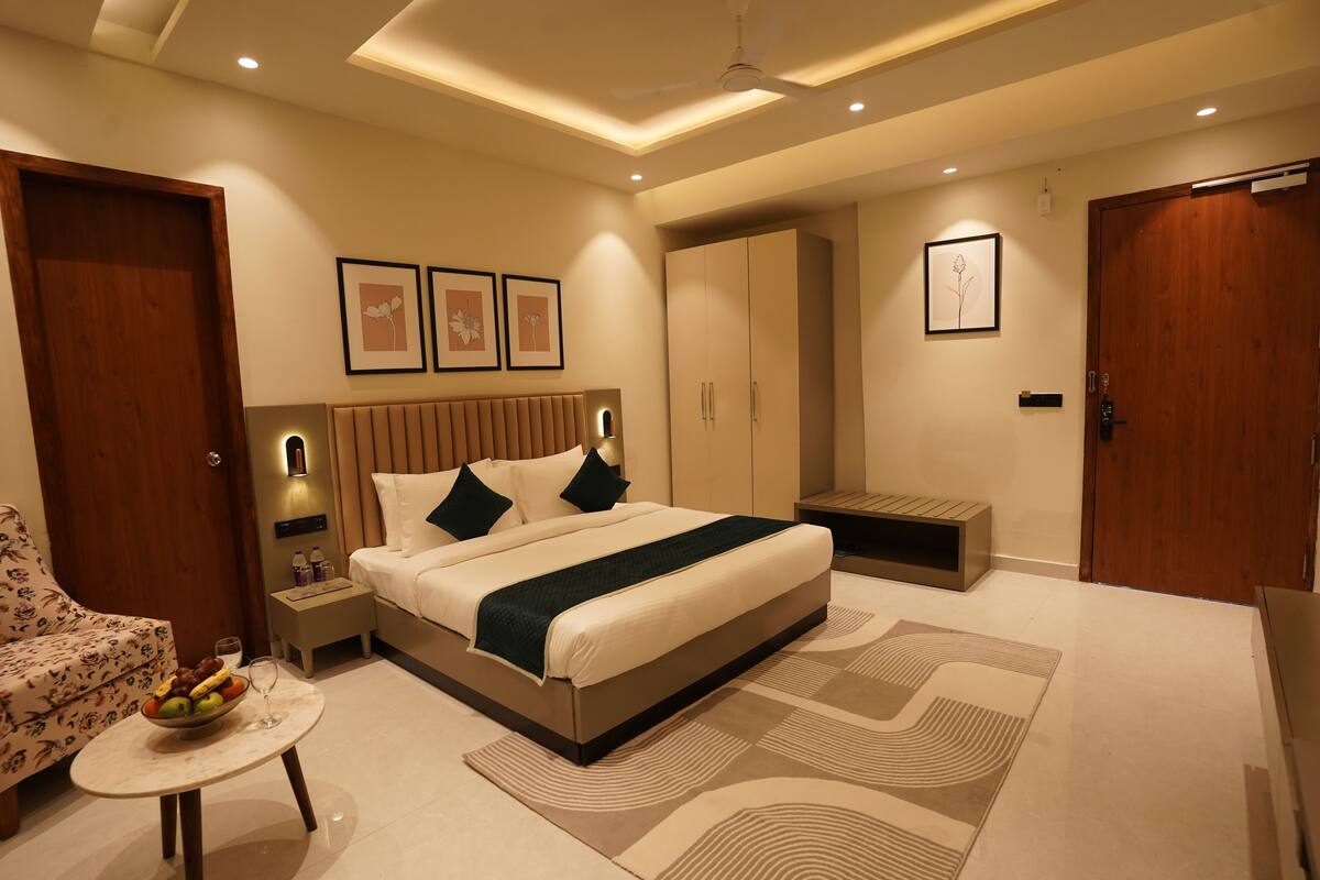 Un dormitorio moderno con una cama grande, mesitas de noche, un sofá y un armario.
