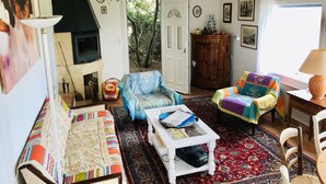 A living room with a sofa, armchairs, a coffee table, a fireplace, a chandelier, and a view of the outdoors. - Sète - La Vigie Singulière (Sète)