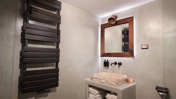 A bathroom with a modern sink, a towel rack, and a mirror with a wooden frame.