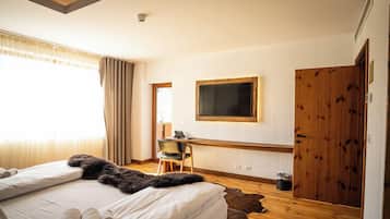 Un dormitorio con cama, escritorio, silla, televisor y armario.