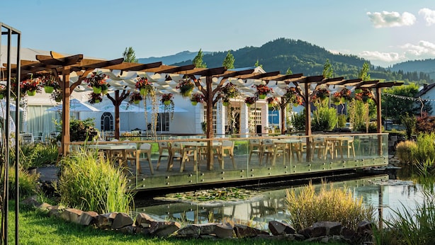Un jardin agrémenté d’une pergola, d’un bassin et offrant une vue sur les montagnes.
