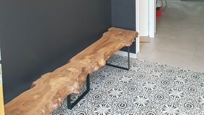A modern interior with a dark wall, a wooden bench, and a hanging light fixture. - Sunny vacation home. Ideally located between lake, beach and forest. (Sanguinet)