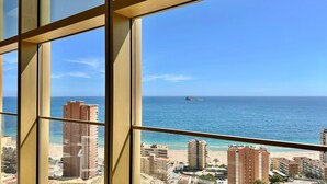 Um edifício alto com vista para o oceano e uma pequena ilha.