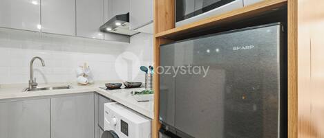 A modern kitchen with a stainless steel refrigerator, a microwave, and a built-in oven.