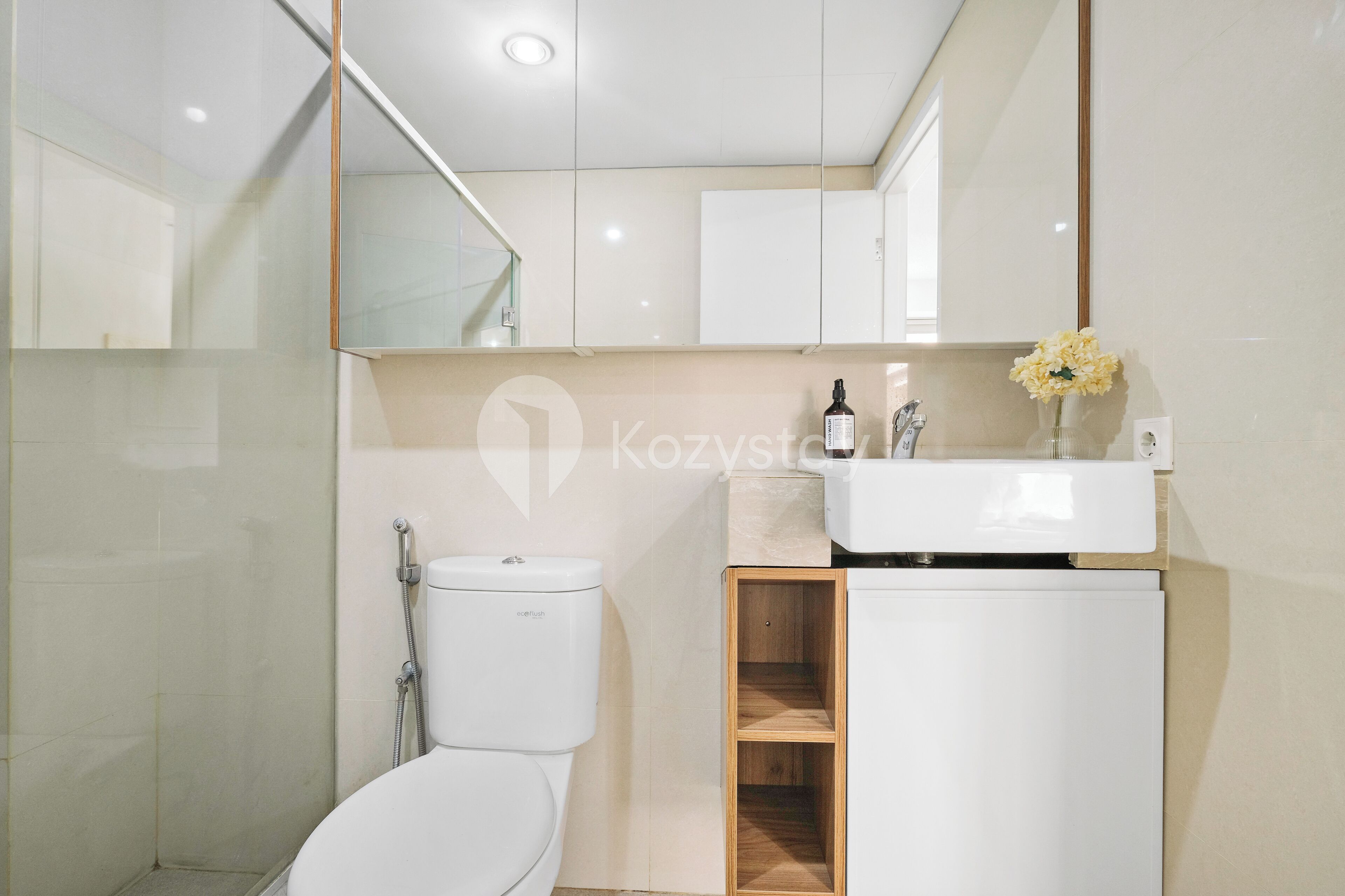 A modern bathroom with a toilet, sink, and mirror.