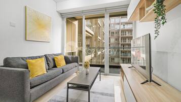 Apartamento, 2 habitaciones, vistas a la ciudad | Zona de estar | Smart TV de 43 pulgadas con canales por cable, Netflix