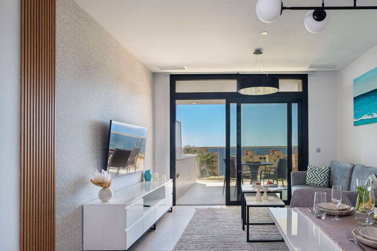 A modern living room with a TV, sofa, and dining area.