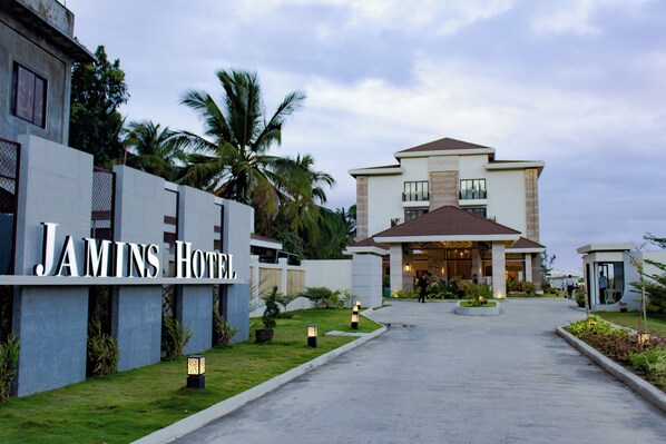Entrada de un hotel con un cartel que dice "JAMINS HOTEL".