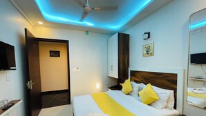 Een hotelkamer met een bed, nachtkastje en plafondventilator.