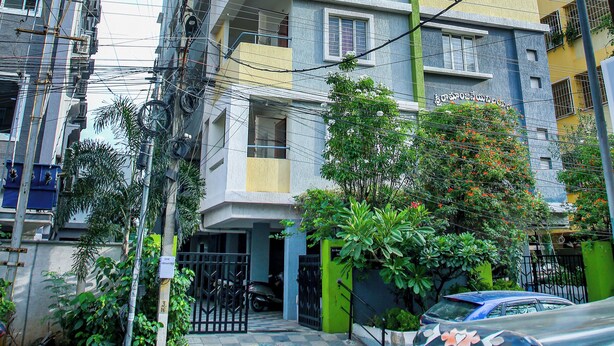 A multi-story residential building with balconies, a gated entrance, and a parked auto-rickshaw. - Sri Ramanjaneya Nilayam (Hyderabad)