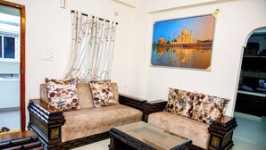 A living room with a sofa set, a coffee table, and a painting of the Taj Mahal on the wall. - Sri Ramanjaneya Nilayam (Hyderabad)