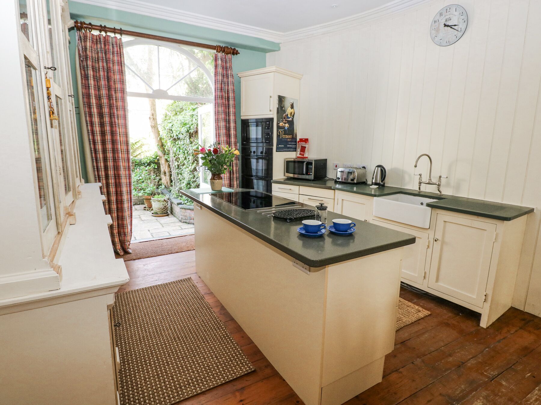A kitchen with a central island, a microwave, a toaster, and a sink.