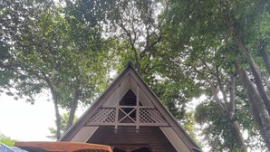 A small, triangular-roofed structure with a wooden porch and a swing set. - Suite Sharilla (Pulau Perhentian Kecil)