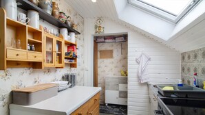 Una cocina compacta con armarios de madera, horno empotrado y tragaluz.