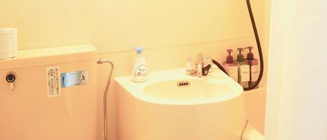A small bathroom with a toilet, sink, and shower.