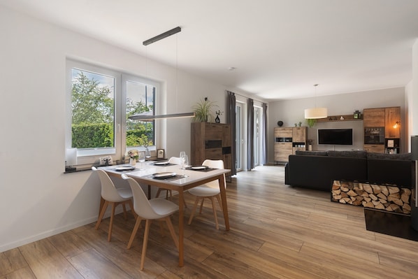 Un espace de vie moderne comprenant un coin repas, une cuisine et un coin salon.