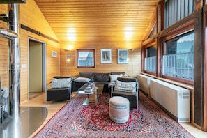 A cozy living room with a sofa set, a coffee table, a rug, and a window with a view.