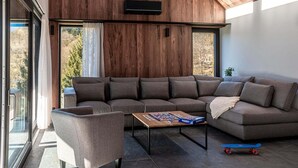 A modern living room with a sectional sofa, a small table, and a skateboard.