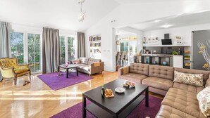 A spacious living room with a large sofa, a coffee table, and a bookshelf. - Holiday House with Pool Villa Seabird (Porec)