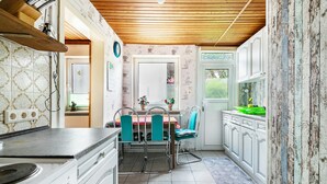 Una cocina con una mesa de comedor, sillas y una ventana.