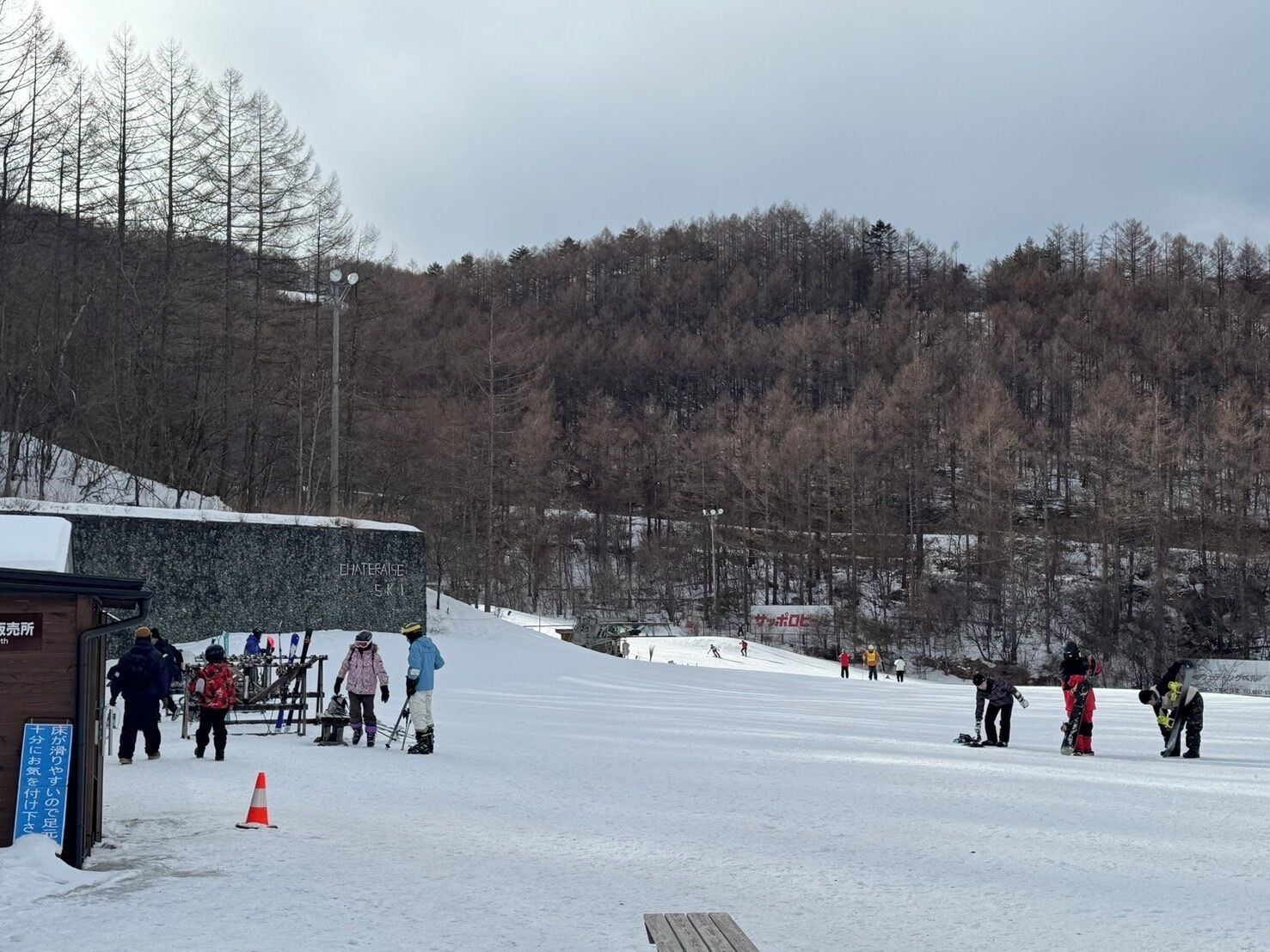 Ein Skigebiet mit einem Gebäude, das „Ski Center“ heißt, und einem Schild, das auf eine Verleihstation hinweist.