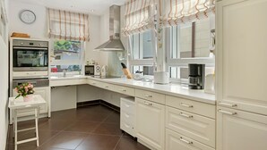 A modern kitchen with a built-in oven, microwave, and coffee maker.