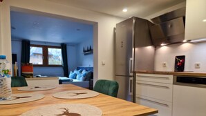 Une cuisine moderne avec une table à manger, des chaises et un réfrigérateur.