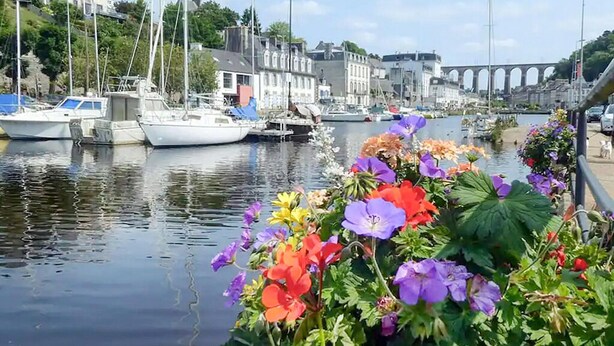 A marina with boats docked, a bridge in the background, and colorful flowers in the foreground. - 4 bedroom stunning home in Plouigneau (Plouigneau)