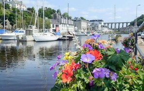 A marina with boats docked, a bridge in the background, and colorful flowers in the foreground. - 4 bedroom stunning home in Plouigneau (Plouigneau)