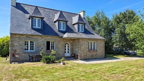 A stone house with a sloped roof, a front porch, and a gravel driveway. - 4 bedroom stunning home in Plouigneau (Plouigneau)