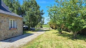 A stone building with a gravel driveway leading to a grassy area with trees. - 4 bedroom stunning home in Plouigneau (Plouigneau)