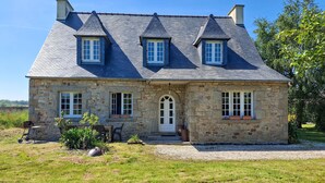 A stone house with a pitched roof, a central door, and two windows on the upper floor. - 4 bedroom stunning home in Plouigneau (Plouigneau)