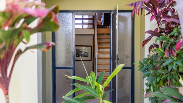 A doorway leading to a staircase with a wooden handrail and a framed picture on the wall.