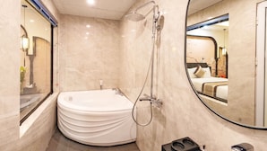 A modern bathroom with a freestanding bathtub, a walk-in shower, and a large mirror. - GRAD Queen Luxury Hotel (Hanoi)