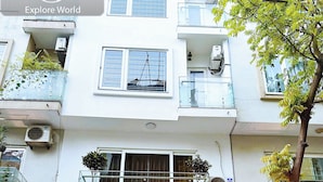 The exterior of the Queen Hotel with a prominent sign, a reception area visible through the entrance, and potted plants around the entrance. - GRAD Queen Luxury Hotel (Hanoi)