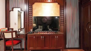 A room with a wooden cabinet, a mirror, and a television. - GRAD Queen Luxury Hotel (Hanoi)
