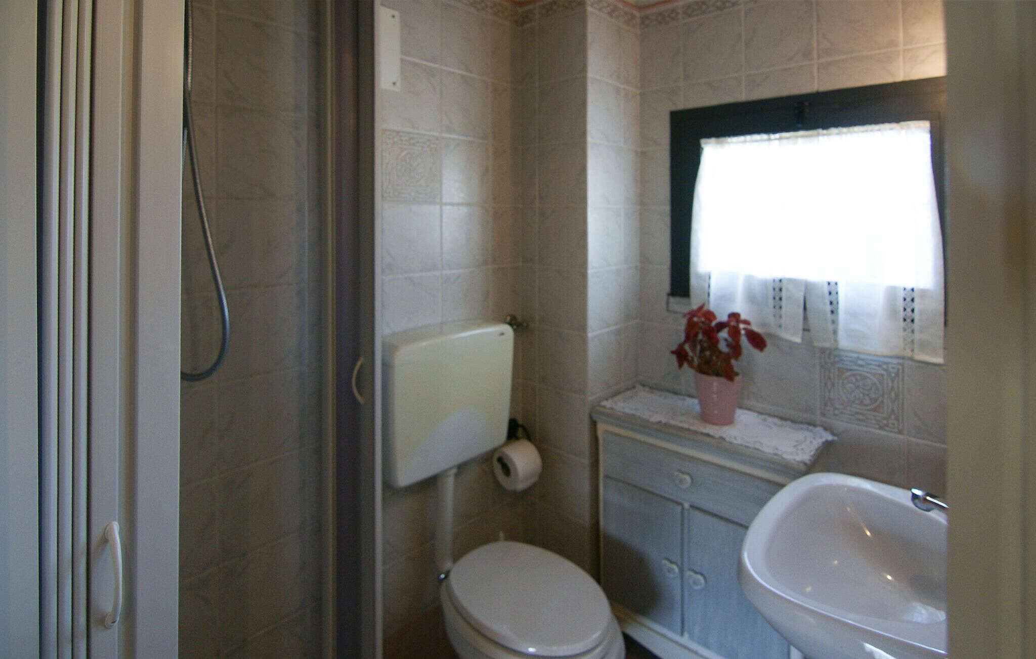 Un baño pequeño con inodoro, lavabo y ducha.