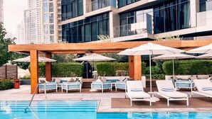 A pool area with lounge chairs and umbrellas, surrounded by a wooden pergola. - Address Dubai Opera 2BR Walk to Mall Burj Khalifa Opera (Dubai)