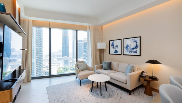 A modern living room with a sofa, armchairs, a coffee table, and a TV. - Address Dubai Opera 2BR Walk to Mall Burj Khalifa Opera (Dubai)
