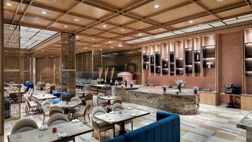 A spacious restaurant with high ceilings, wooden paneling, and a variety of seating options including tables and booths.