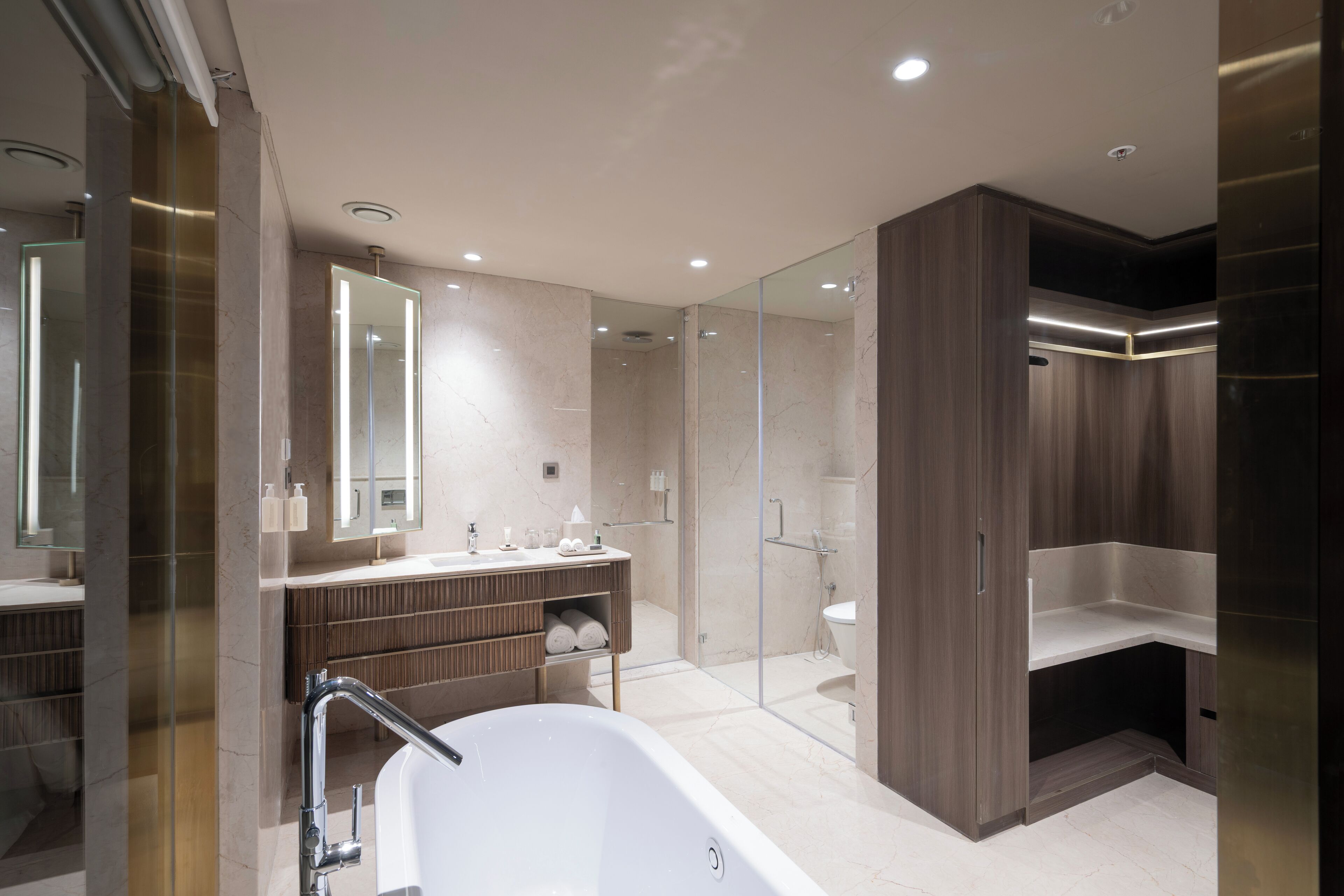 A modern bathroom with a freestanding bathtub, a glass-enclosed shower, and a vanity with a mirror.
