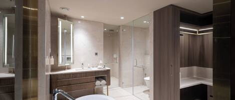 A modern bathroom with a freestanding bathtub, a glass-enclosed shower, and a vanity with a mirror.