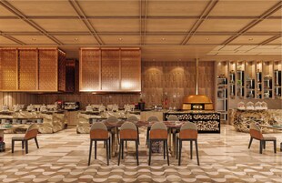 Un restaurante moderno con un área de comedor central, un bar y una cocina visible al fondo.