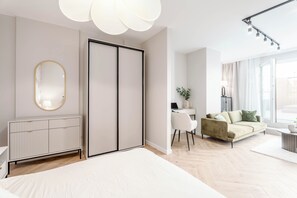 Une chambre moderne avec un grand lit, une armoire, un bureau et un canapé.