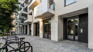 A modern building with a bike parking area and a gated entrance. - Luxurious Brand New! Private Jacuzzi + Terrace + Parking (Warszawa)