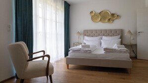 Una camera da letto con un letto grande, una sedia e un'opera d'arte a parete.
