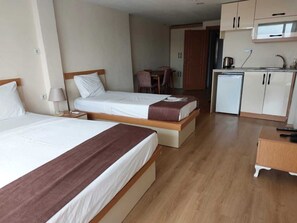 A hotel room with two beds, a kitchenette, and a small dining area. - N-V Suites (Istanbul)